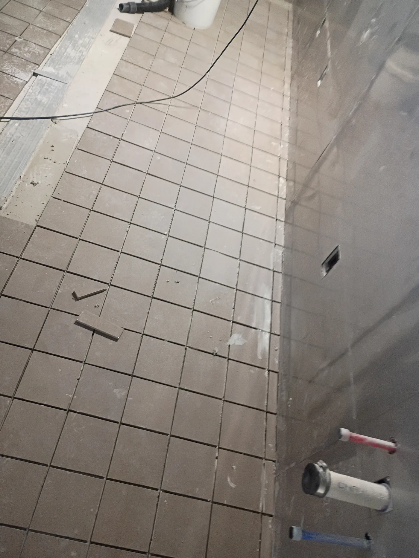 Large format floor tile being set in a bathroom
